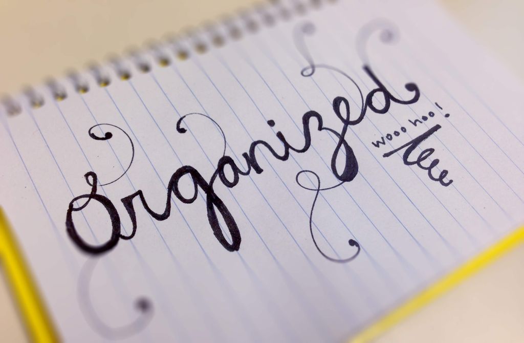 Close-up of a notebook page with handwritten text 'Organized' and 'Worse than'.
