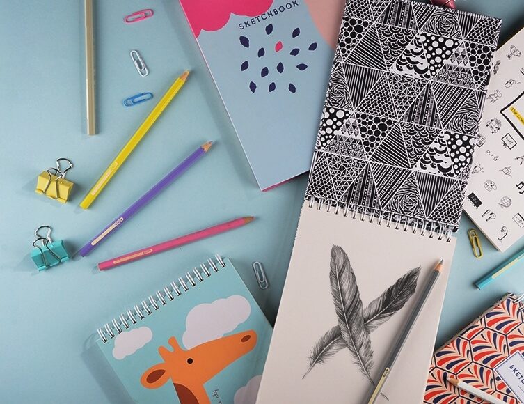 Buku sketsa, pensil, dan klip sebagai ilustrasi perencanaan desain banner promosi