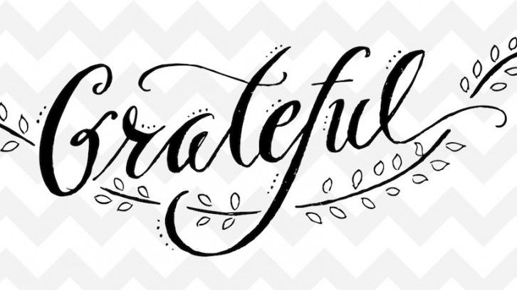 Ilustrasi calligraphy 'Grateful' dengan pola zigzag putih dan hitam.