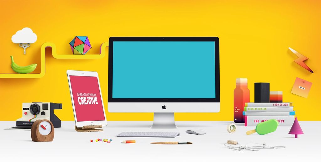 Workspace dengan peralatan dan aksesori desain modern di latar belakang kuning.