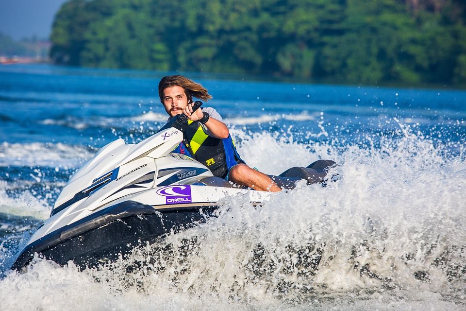 Pemandu jetski menunjuk ke depan saat meluncur di sungai