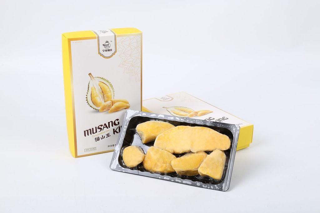 Packaging Musang King Durian dan potongan buah durian di dalam kotak plastik.