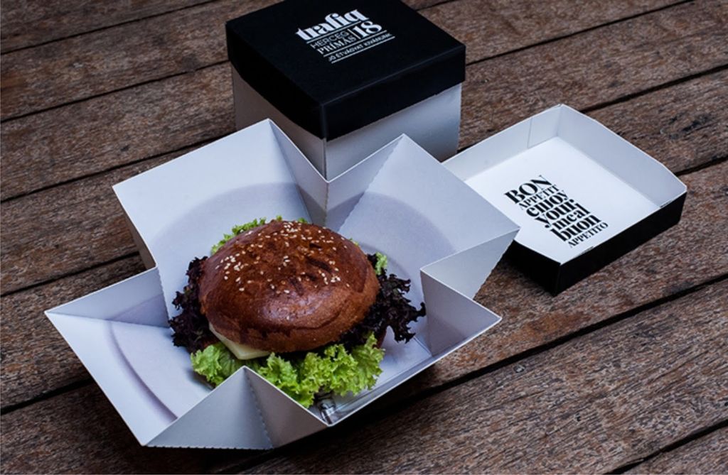 Hamburguer dengan lapisan sayuran dan roti kacang di kotak kraft putih
