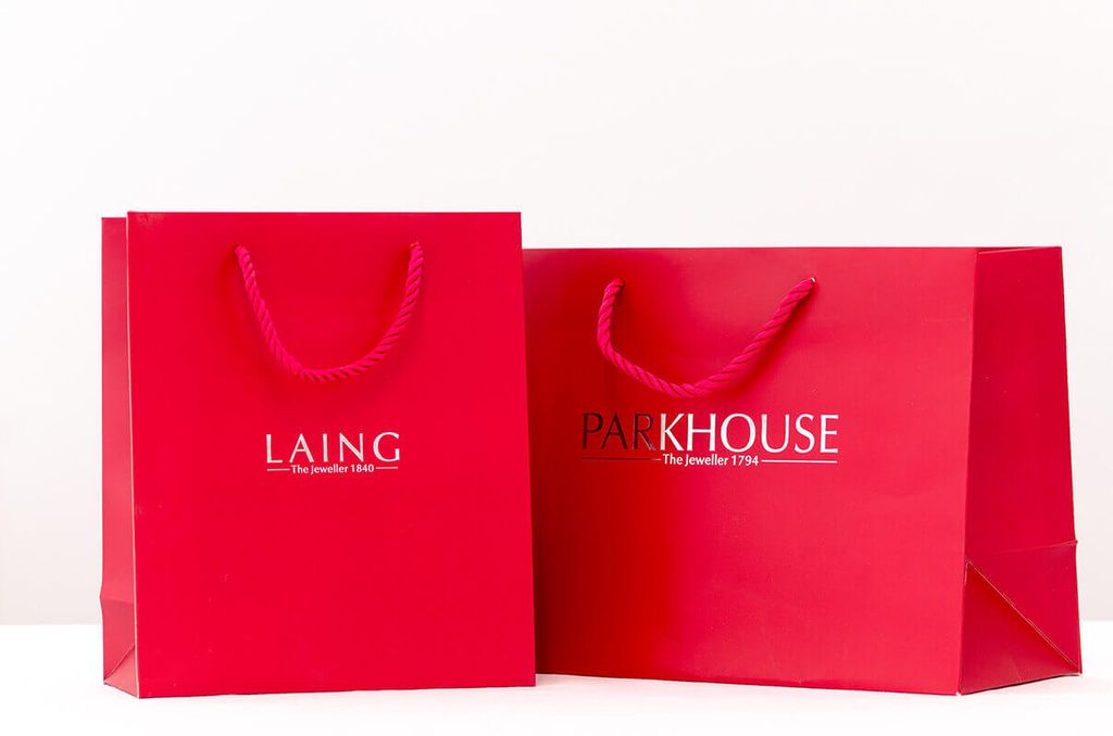 Dompet branded merah dengan logo Laing dan Parkhouse, ideal untuk promosi perusahaan.
