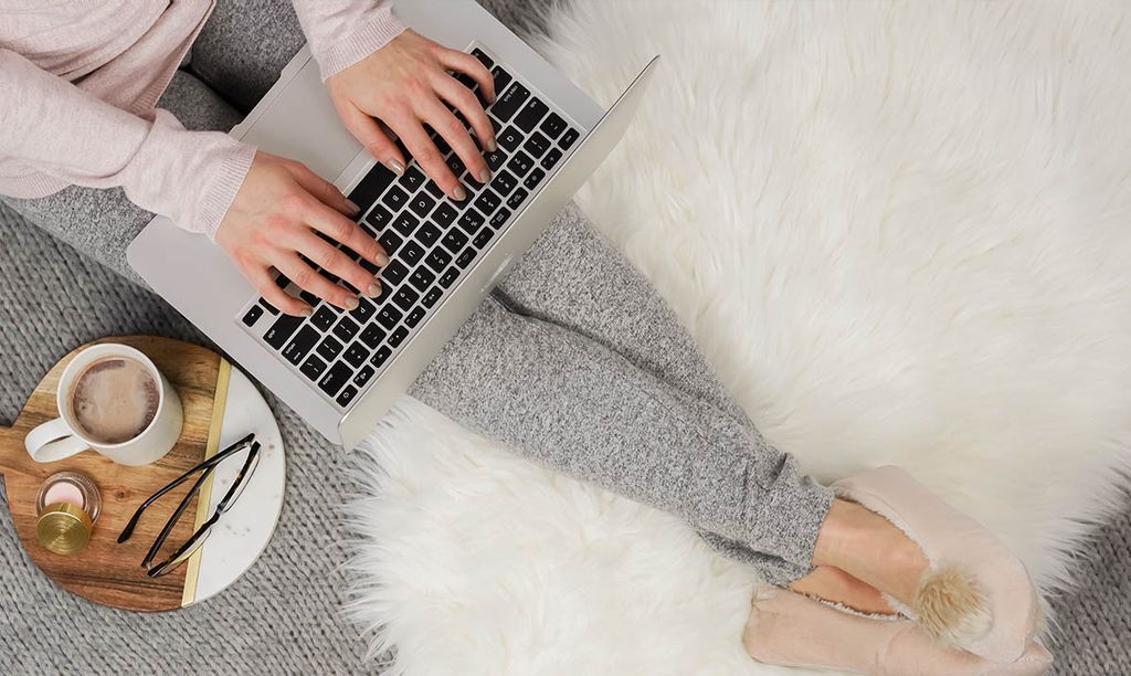 Orang mengetik di laptop di atas karpet putih