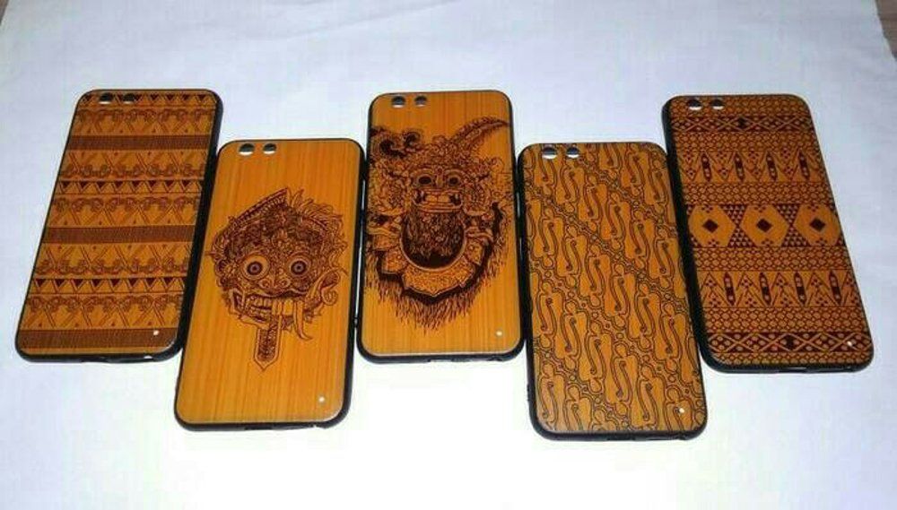 Casing HP kayu dengan motif batik dan masker tradisional, produk unik untuk pecinta seni.