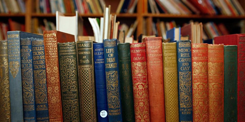 Barisan buku antik berwarna-warni di perpustakaan.