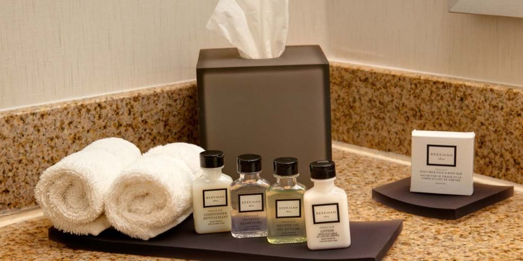 Perawatan badan dengan produk Beekman 1802 dan handuk di meja granit.