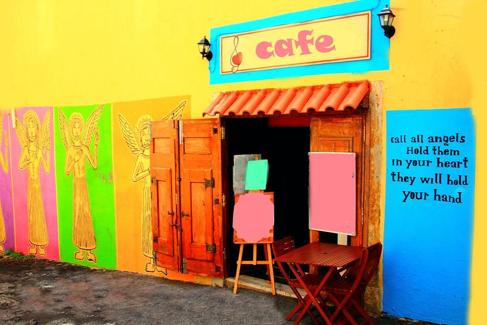 Cafe dengan mural anggel dan pesan inspiratif di dinding sebagai ilustrasi poster dan signage coffee shop baru