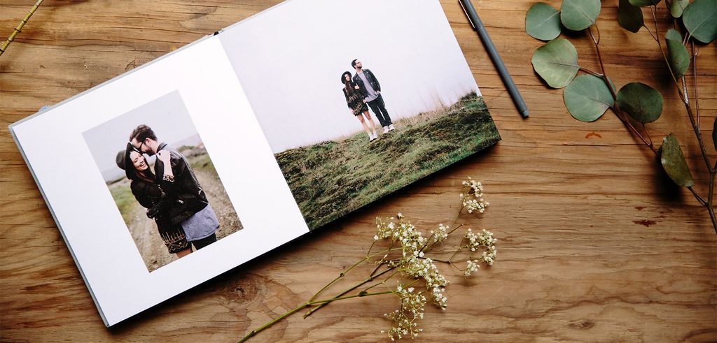 Buku foto terbuka dengan foto pasangan di alam, bunga, dan pensil.