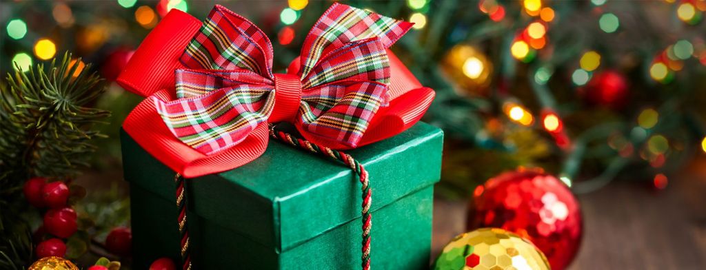 Hadiah Natal hijau dengan simpul tartan merah dan hiasan Natal