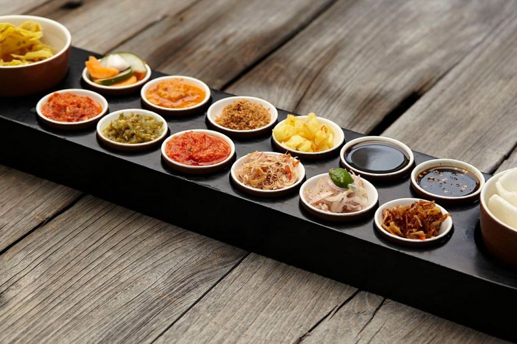 Variety of small bowls containing different types of condiments and garnishes.