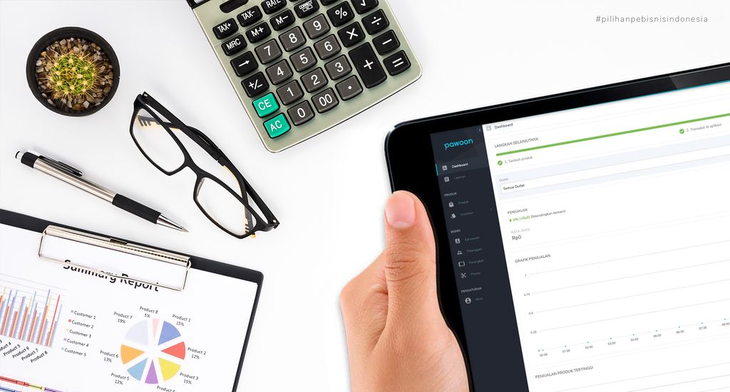Tabel laporan keuangan, kalkulator, dan tablet dengan aplikasi Pawoon untuk mengevaluasi omzet bisnis