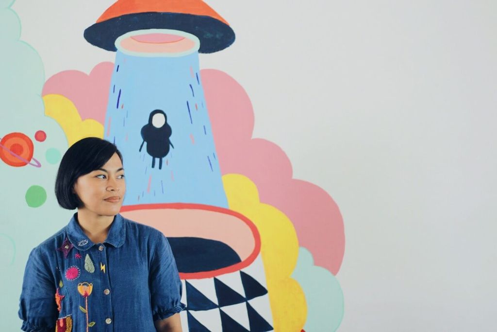 Ilustrasi UFO dengan cahaya ungu dan figura manusia di belakangnya
