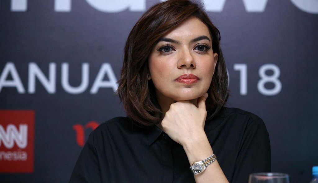 Wanita memandang ke samping dengan tangan di pipi, latar belakang bertuliskan 'ANUAR 2018'.