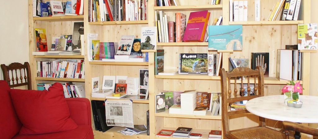 Rak buku kayu berisi berbagai buku dan majalah di ruang tamu