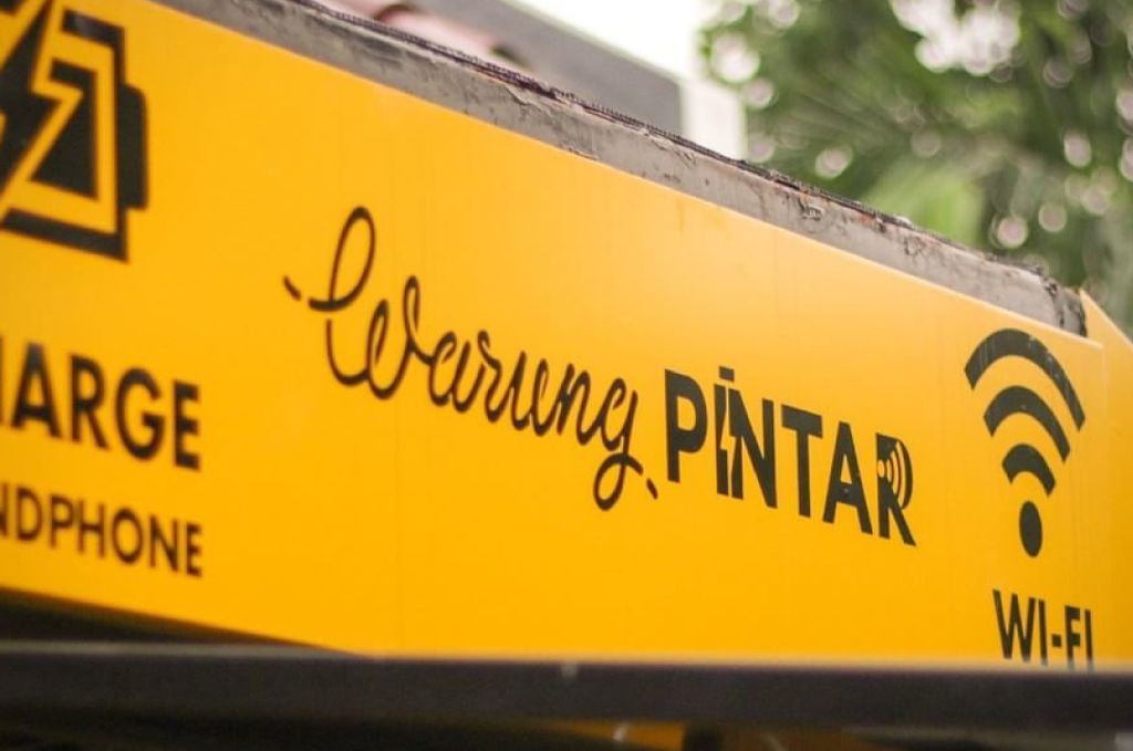 Logo Warung Pintar dengan ikon Wi-Fi dan layanan charge dan handphone.
