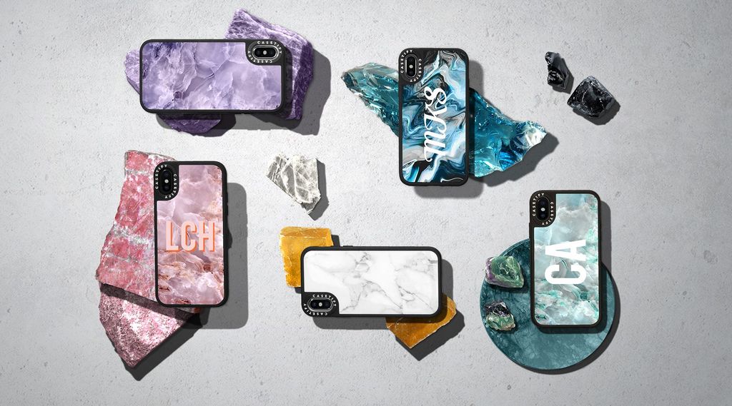 Beberapa case iPhone dengan desain unik dan estetika alami, terletak di atas batu-batu mineral.