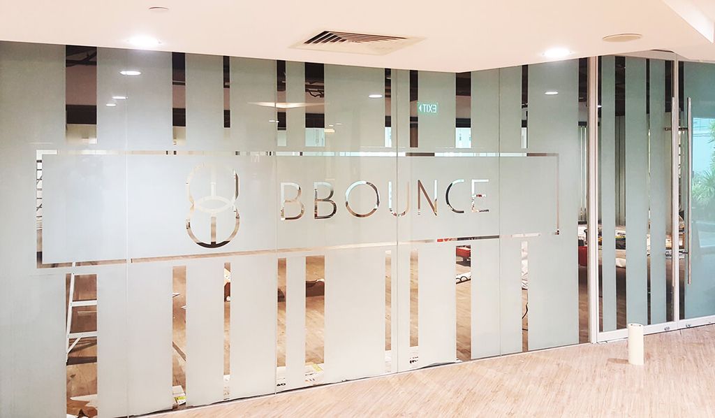 Pintu kantor transparan dengan logo Bounce, desain minimalis modern.