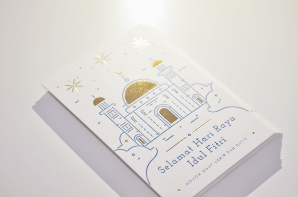 Brosur ucapan Selamat Hari Raya Idul Fitri dengan gambar masjid emas dan putih.