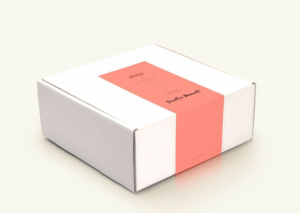 Kotak perangko putih dengan label merah dan tulisan elegan, cocok untuk branding.