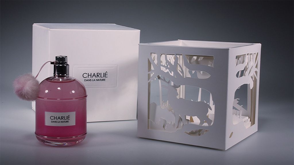 Perfume bottle and decorative cutout box for Charliee perfume.
