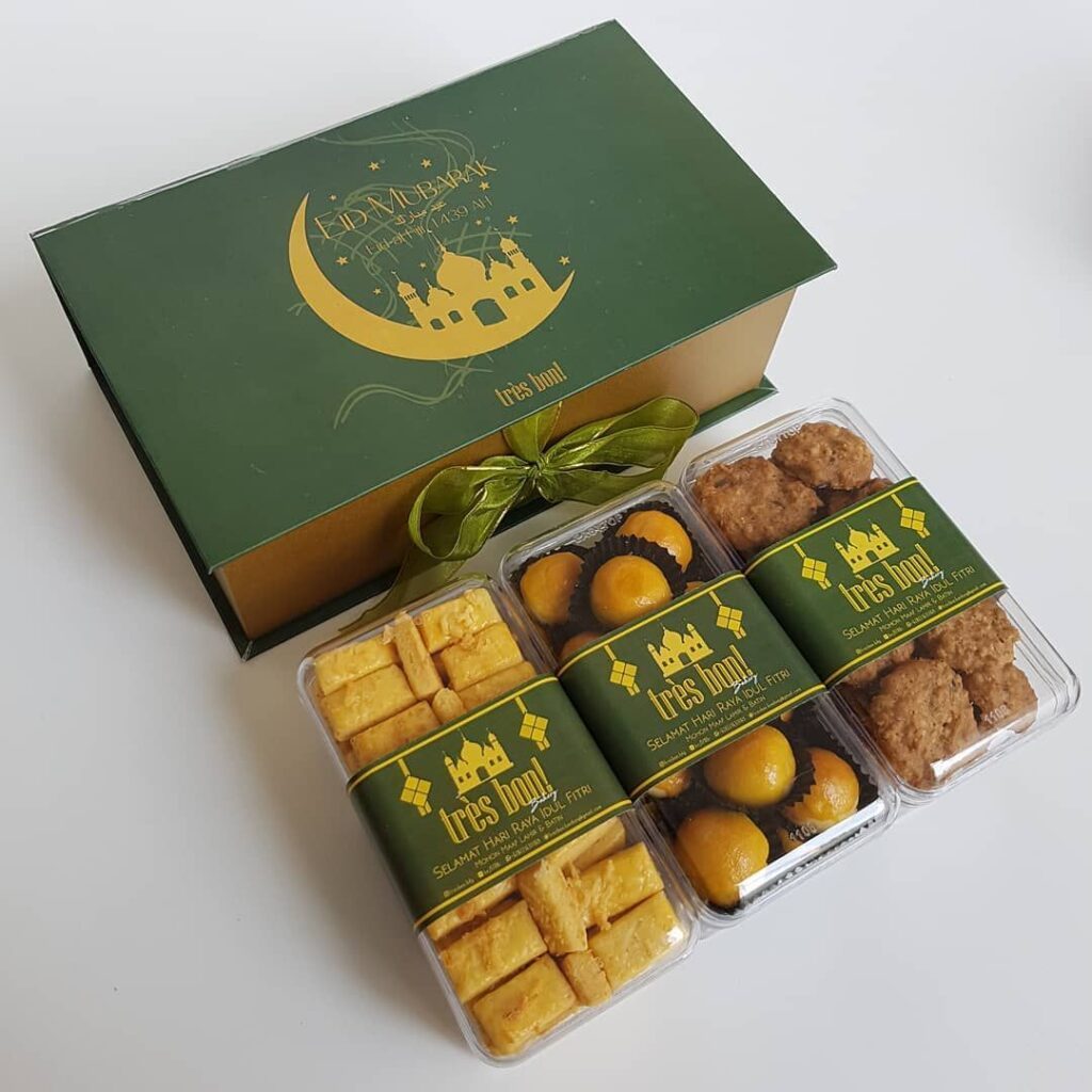 Kue tradisional dalam kotak hadiah berwarna hijau dengan tema Idul Fitri.