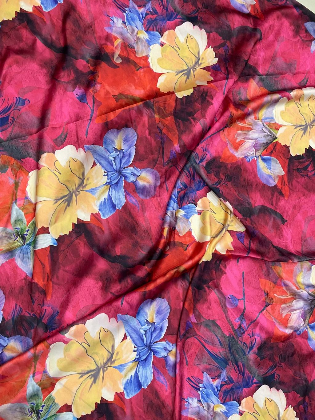 Kain batik dengan motif bunga warna-warni dan tekstur halus.