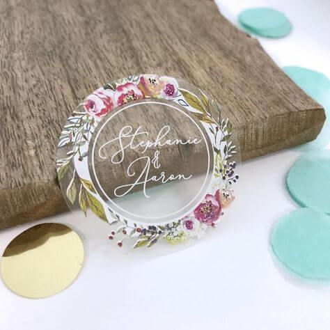 Stiker transparan dengan motif bunga dan nama pengantin, cocok untuk dekorasi pernikahan.