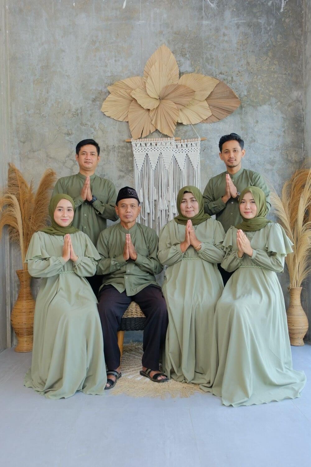 Grup orang mengenakan baju Muslim modern dengan pose salam tradisional.