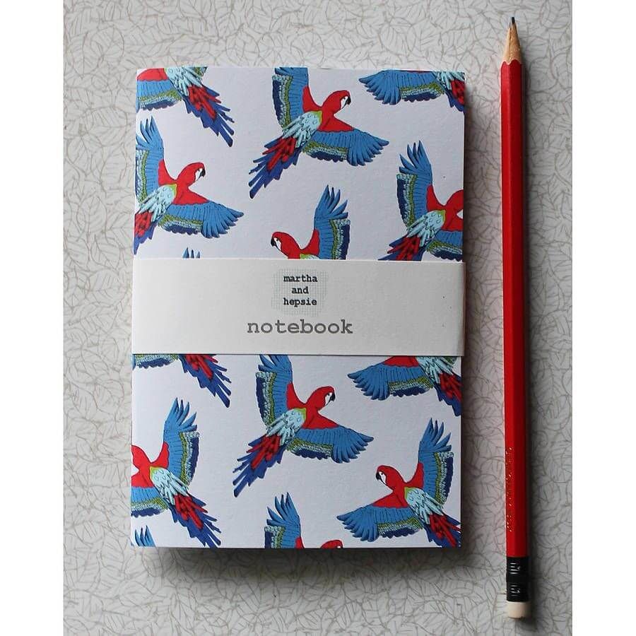 Notebook dengan desain burung macaw dan pensil merah