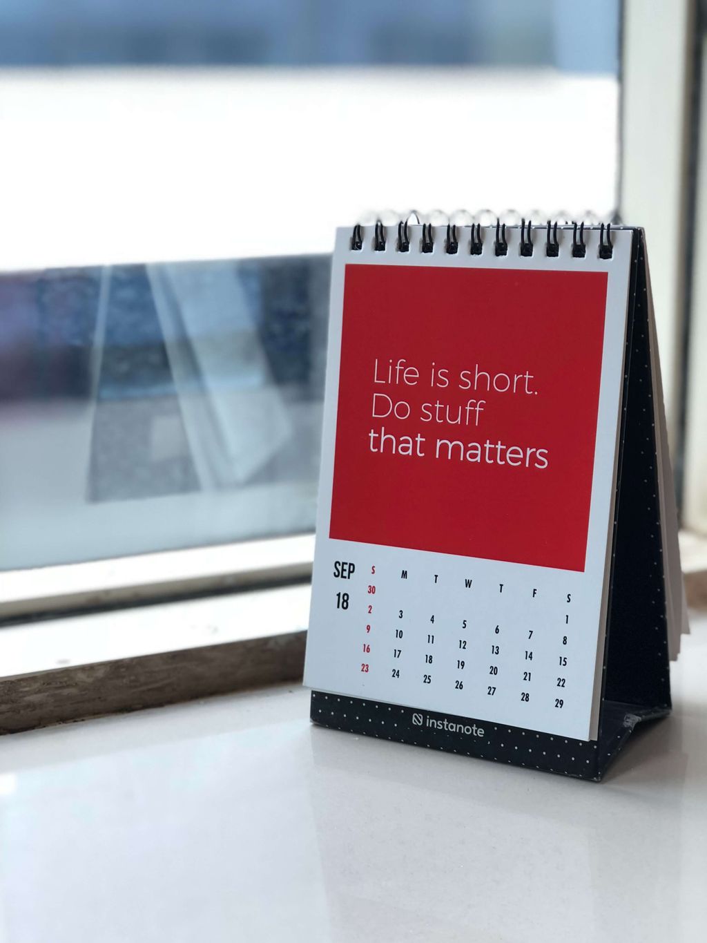 Kalender meja dengan pesan motivasi 'Life is short. Do stuff that matters'.