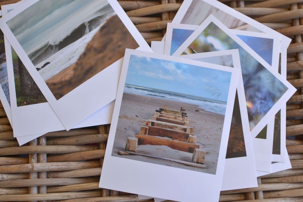 Galeri Polaroid dengan pemandangan pantai dan jalan kayu.