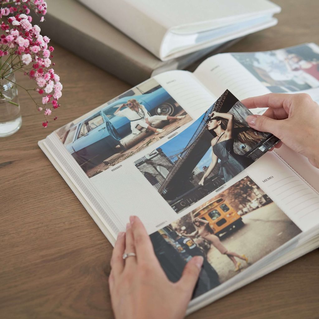 Tangan memegang dan menunjuk foto dalam buku foto.