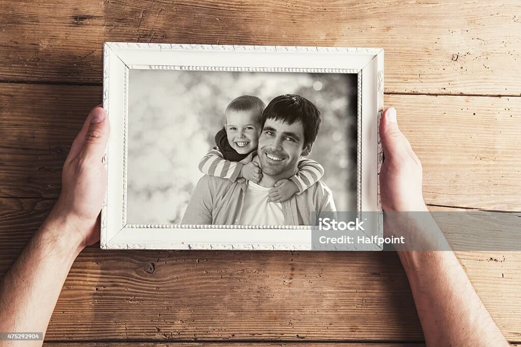 Foto hitam putih orang tua dan anak di dalam frame putih