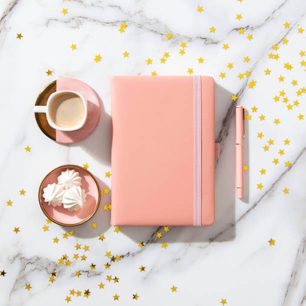 Aset visual Uprint.id: buku, cangkir kopi, dan marshmallow di atas latar belakang marmer dengan bintang emas.