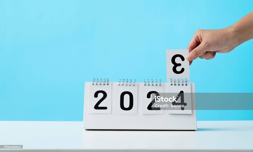Tangan mengubah tanggal dari 2024 menjadi 2023 pada kalender