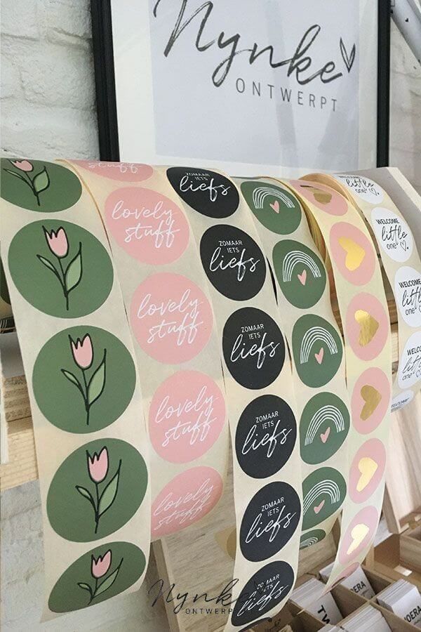 Roll of colorful stickers featuring tulips, rainbows, and text in Dutch and English.