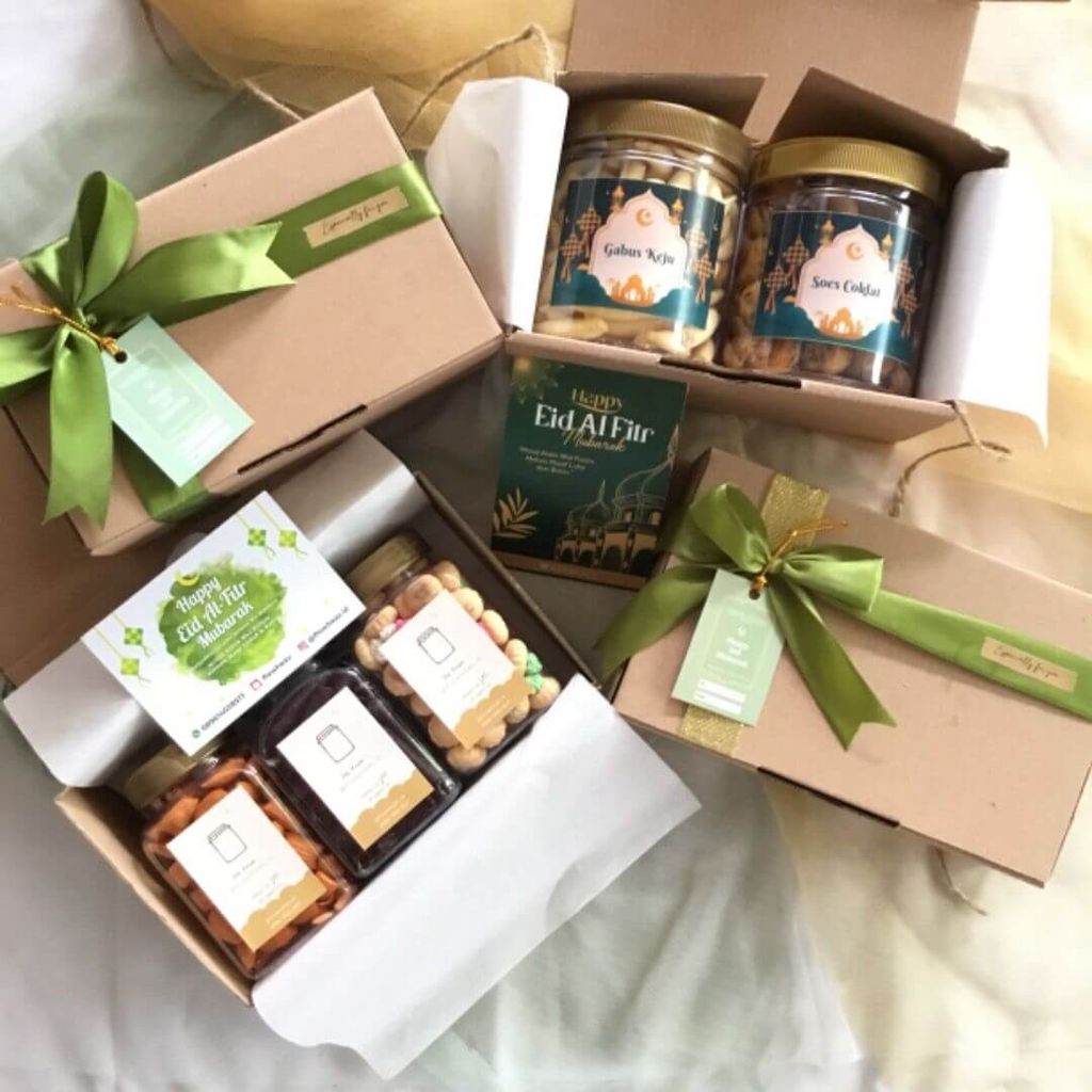 Keranjang hadiah lebaran berisi kue, kacang, dan minuman dalam kotak-kotak kecil.