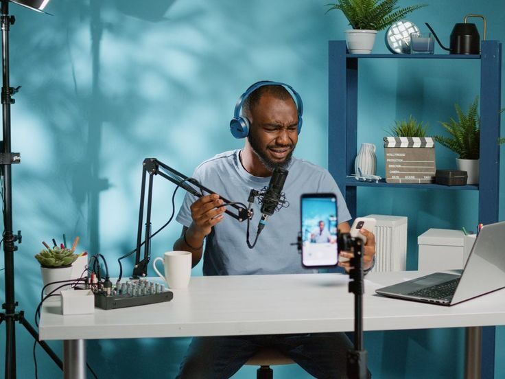 Pria sedang melakukan podcasting dengan alat profesional di studio.