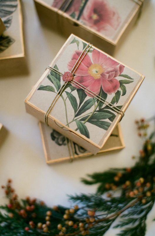 Paket hadiah kotak kecil dengan desain bunga dan daun, dipotong dengan tali.