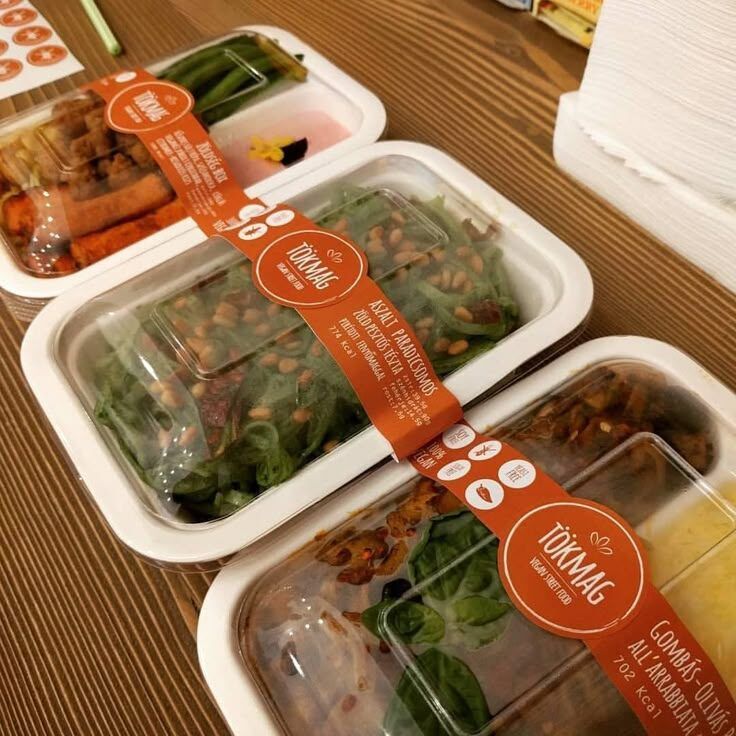 Kotak makanan plastik dengan label 'Tükmag' berisi sayuran dan bahan lainnya.