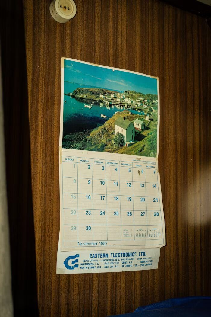 Kalender bulan November 1987 dengan foto pantai dan rumah-rumah di tepi pantai