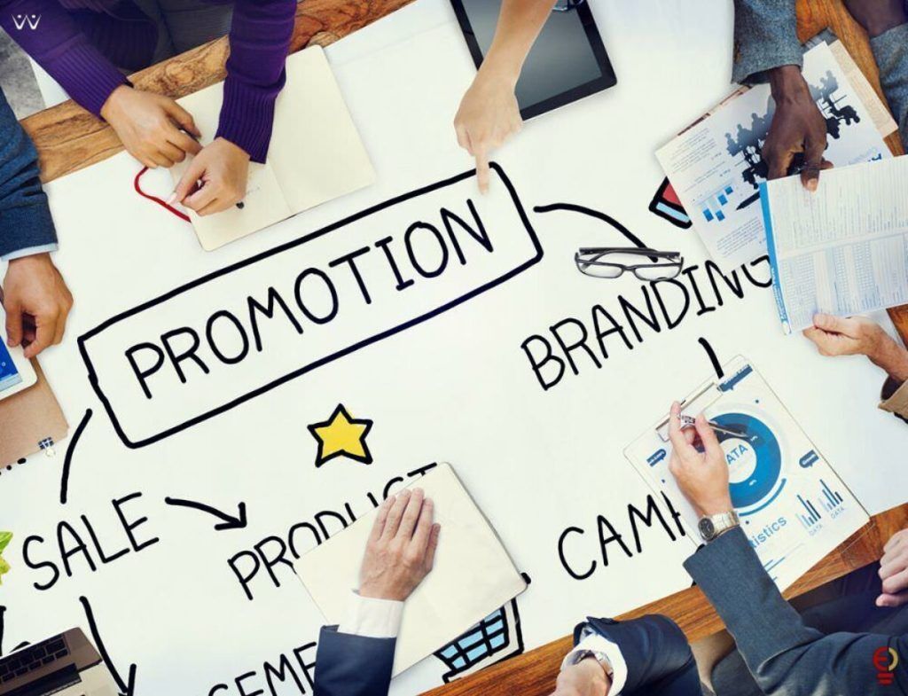 Tabel strategi promosi dan branding dengan tangan menunjuk pada elemen-elemennya.