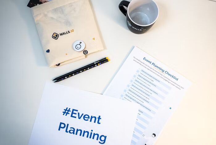 Peralatan dan checklist event planning di meja kerja.