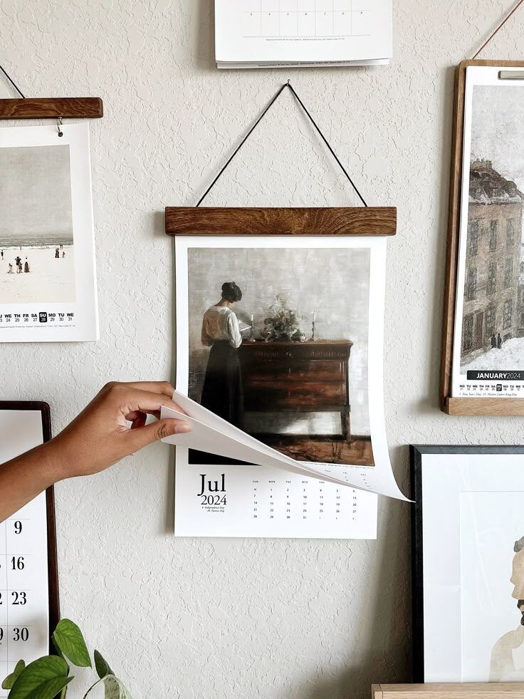 Pajangan kalender bulan Juli 2024 dan gambar wanita di dinding rumah.