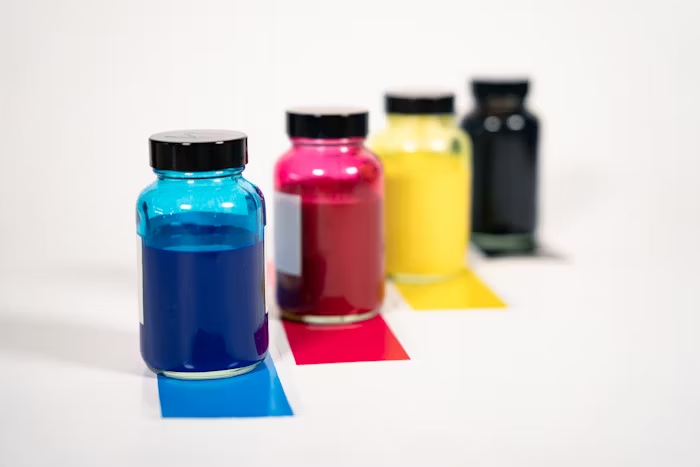 Empat botol pigmen warna biru, merah, kuning, dan hitam.