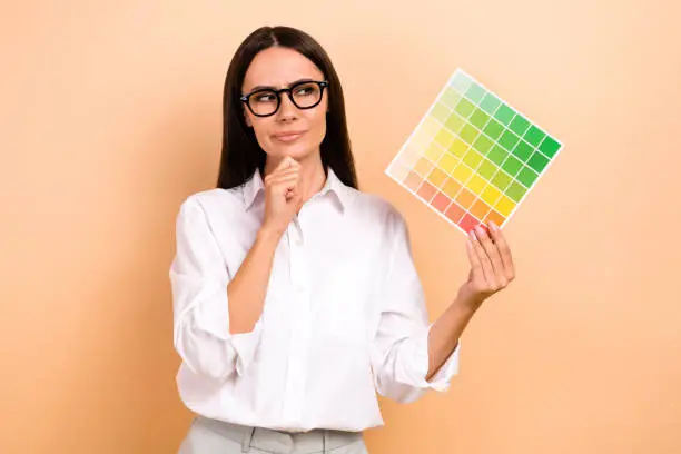 Desainer grafis memegang palet warna dan berpikir.
