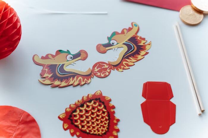 Gambar menunjukkan desain aset visual untuk percetakan online, termasuk maskot naga dan elemen dekoratif.