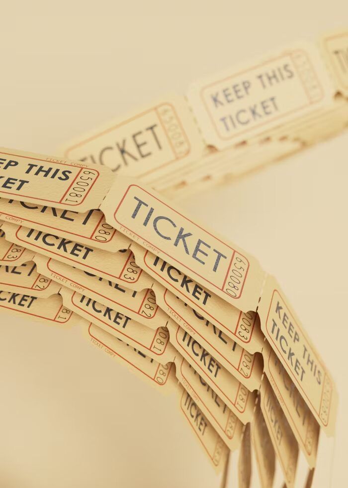 Tumpukan tiket kertas bertuliskan 'TICKET' dan 'KEEP THIS TICKET' dalam urutan vertikal.